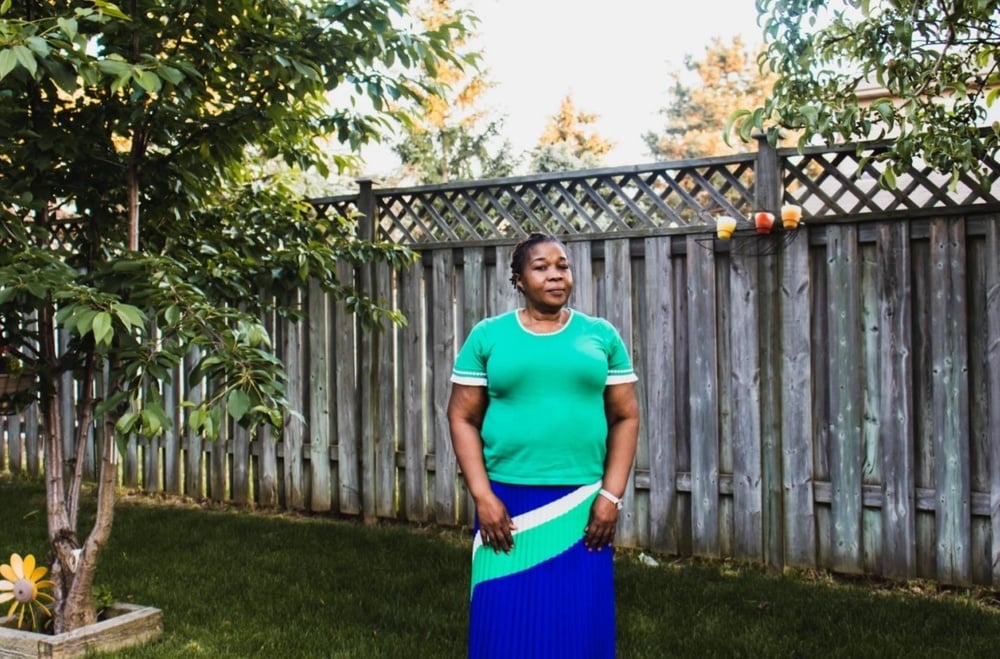 black-woman-stands-looking-towards-camera