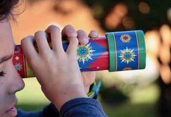 Child looking through kaleidoscope