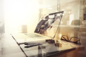 Office workplace with laptop and smart phone on wood table and london city blurred background