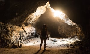 girl staring into sunlight cave