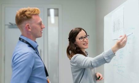 two young people at a whiteboard