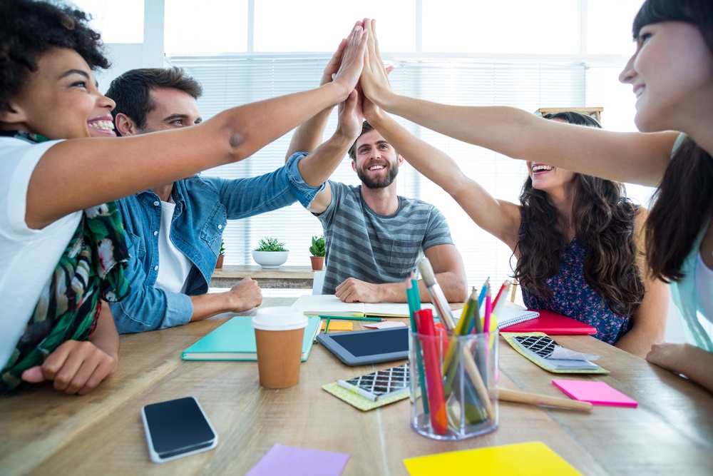 Creative business team putting hands together at the office.jpeg