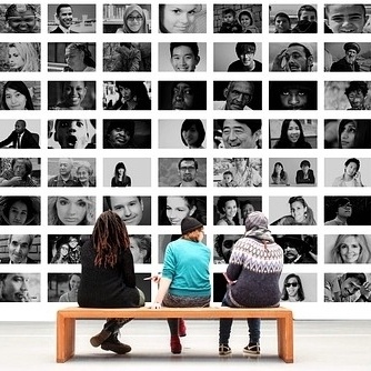 people looking at wall of faces