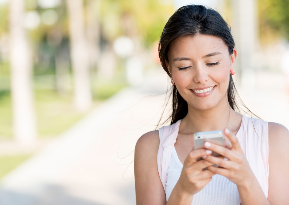 Portrait of a woman sending text message from her phone.jpeg
