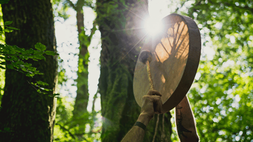 Gros plan d'un.e person.ne jouant d'un tambour à main traditionnel