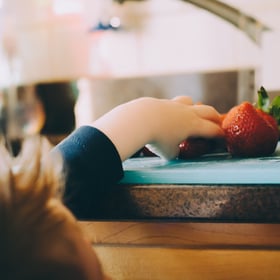 child eating strawberries