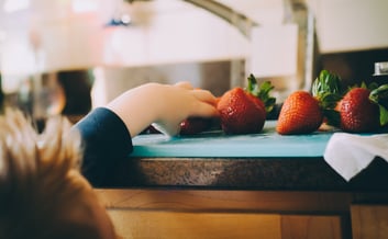 child eating strawberries