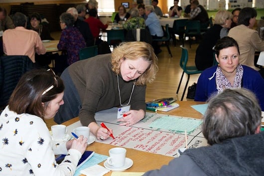 A group of people sitting around a table

Description automatically generated