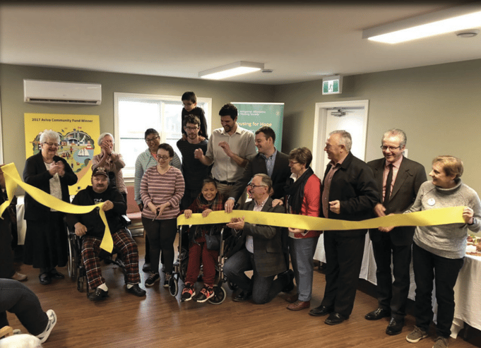 A group of people cutting a ribbon

Description automatically generated