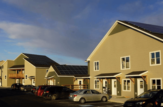 A row of houses with cars parked in front of them

Description automatically generated