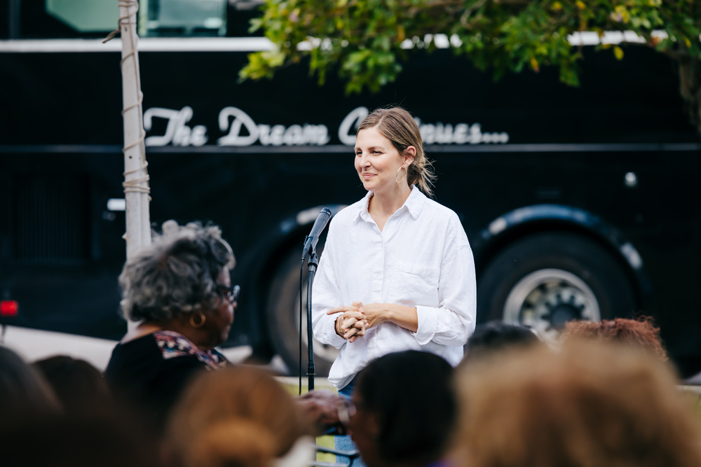 souriant-femme-parlant-micro-foule-diverse-dehors