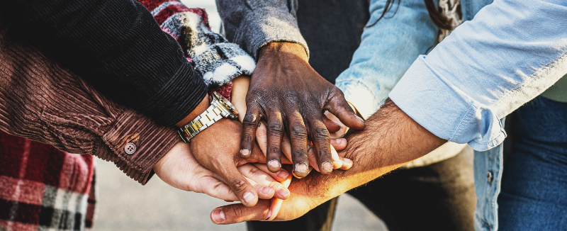 Many people putting their hands together 