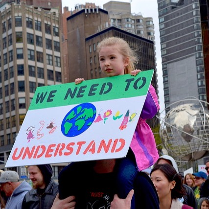 Little girl holding sign to protect environment