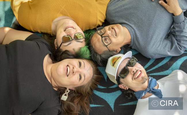 A group of Indigenous people smiling and looking up, photo courtesy of CIRA